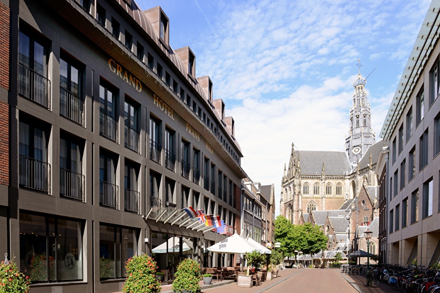 Amrâth Grand Hotel Frans Hals in Haarlem with the Grote Kerk in the background, modern facade with classical surroundings.
