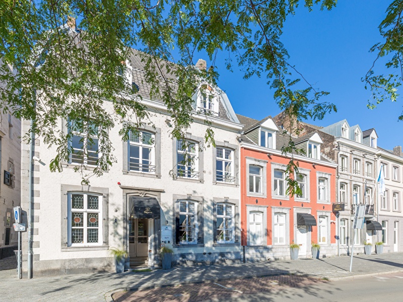 Voorzijde van Amrâth Hotel Bigarré in Maastricht, historisch gebouw met witte en rode gevels in een rij herenhuizen.