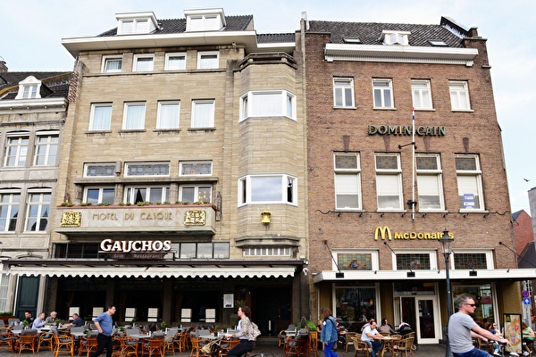 Voorzijde van Amrâth Hotel DuCasque in Maastricht, een klassiek gebouw met stenen gevel en vlaggen.