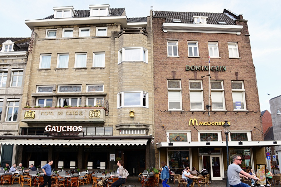 Front of Amrâth Hotel DuCasque in Maastricht, a classic building with a stone facade and flags.