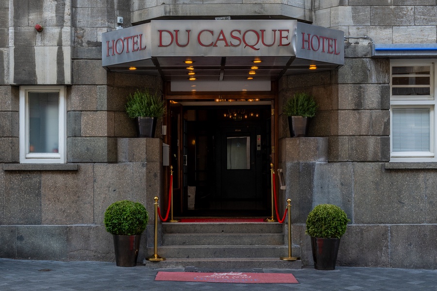 Voorzijde van Amrâth Hotel DuCasque in Maastricht, een klassiek gebouw met stenen gevel en vlaggen.