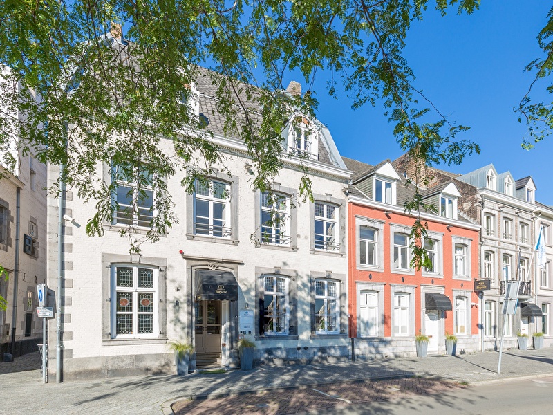 Front of Amrâth Hotel Bigarré in Maastricht, historical building with white and red facades in a row of townhouses.