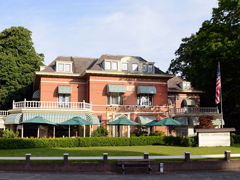 Exterieur aanzicht van Amrâth Hotel Lapershoek Arenapark in Hilversum, charmante villa met groene luifels.
