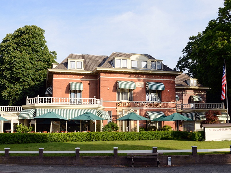 Exterieur aanzicht van Amrâth Hotel Lapershoek Arenapark in Hilversum, charmante villa met groene luifels.
