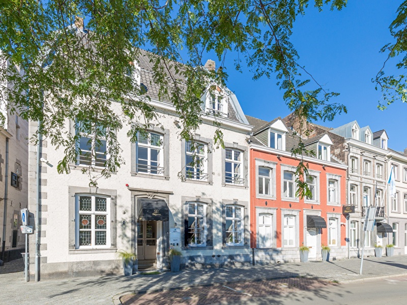 Voorzijde van Amrâth Hotel Bigarré in Maastricht, historisch gebouw met witte en rode gevels in een rij herenhuizen.