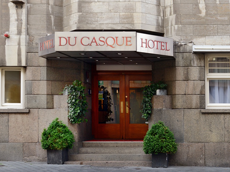 Voorzijde van Amrâth Hotel DuCasque in Maastricht, een klassiek gebouw met stenen gevel en vlaggen.