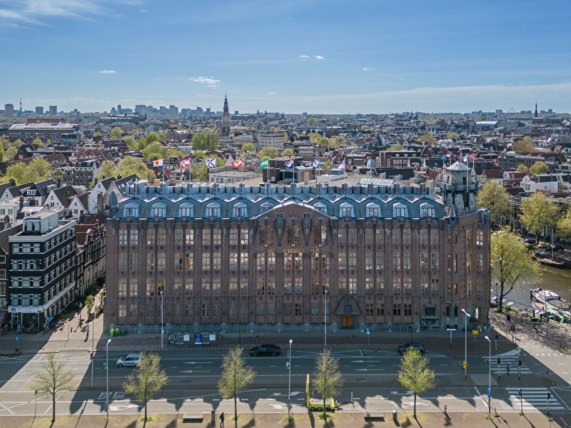 Grand Hotel Amrâth Amsterdam met stadspanorama op de achtergrond.