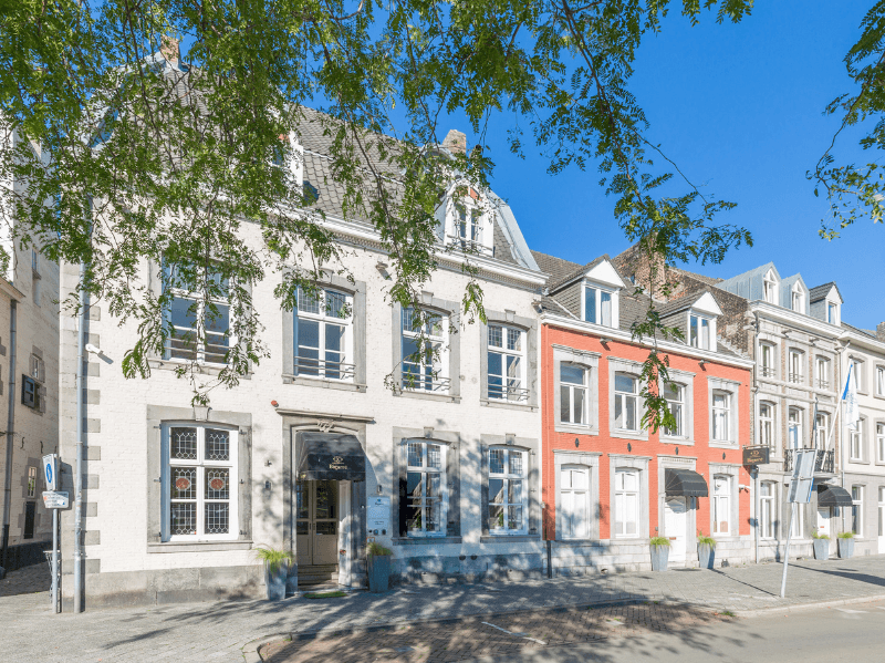 Voorzijde van Amrâth Hotel Bigarré in Maastricht, historisch gebouw met witte en rode gevels in een rij herenhuizen.