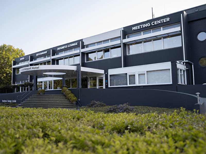 Amrâth Airport Hotel Rotterdam, modern building with a business look, wide staircase and spacious entrance.